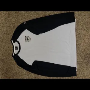Nike Men’s Las Vegas Raiders SLV/BLK Historic Raglan Crew Performance Sweater